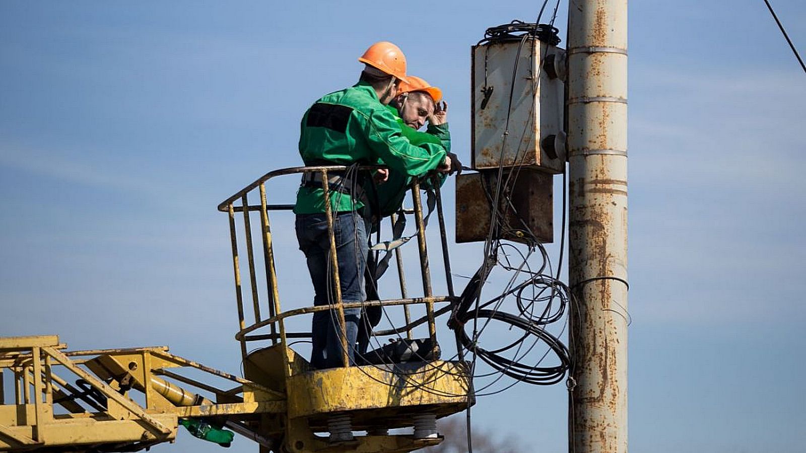 Power engineers are repairing the power grid on a truck-mounted tower